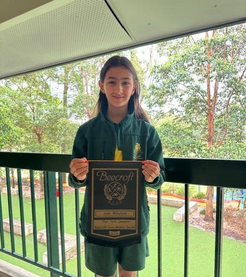 Student holding a Zone Athletics award