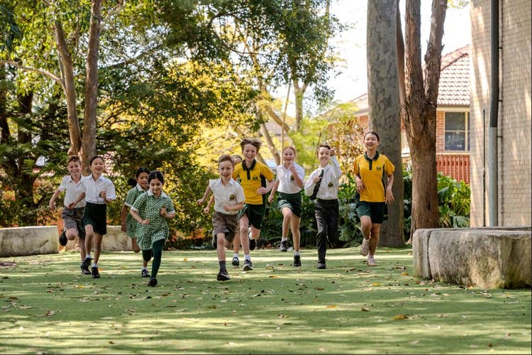 9 students running in a horizontal line across the playground.
