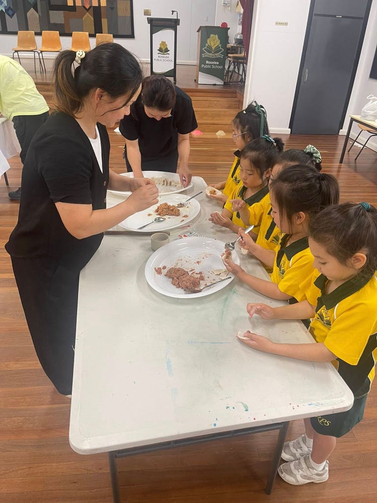 Mandarin students learning to make dumplings with a parent helper.