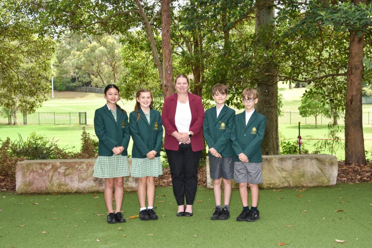 Principal standing in the middle of school captains and vice captains in a straight line.