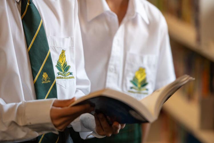up close photo of two students holding a book