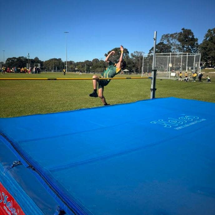 Student leaping over a high jump bar