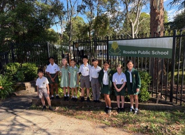 Group of students standing in front of the school gate