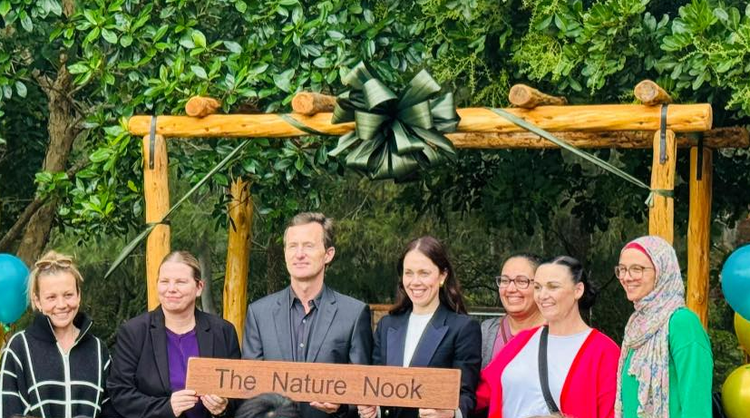 Group of adults holding a sign for the name of the new playground on the opening day