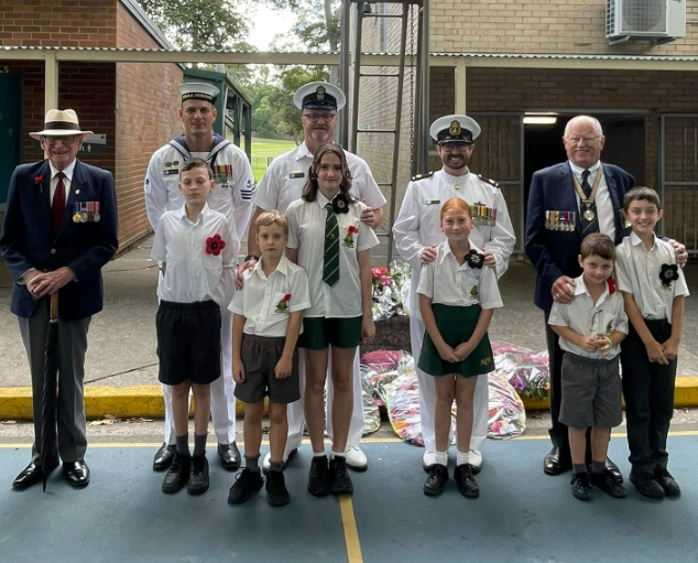 Group of military service men and their children standing in a line.